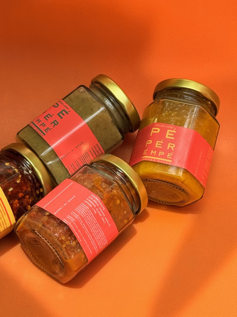 Jars of pepper sauce on an orange backdrop